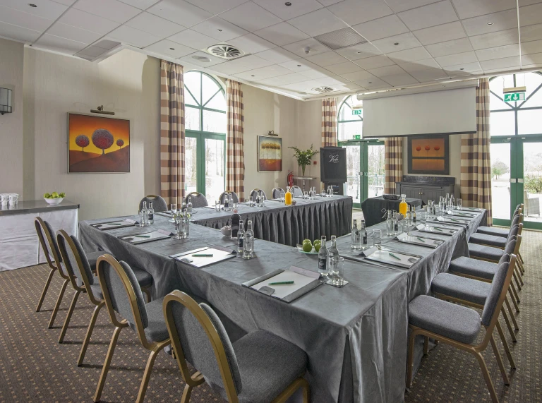 A conference room with tables and chairs set in rectangle.