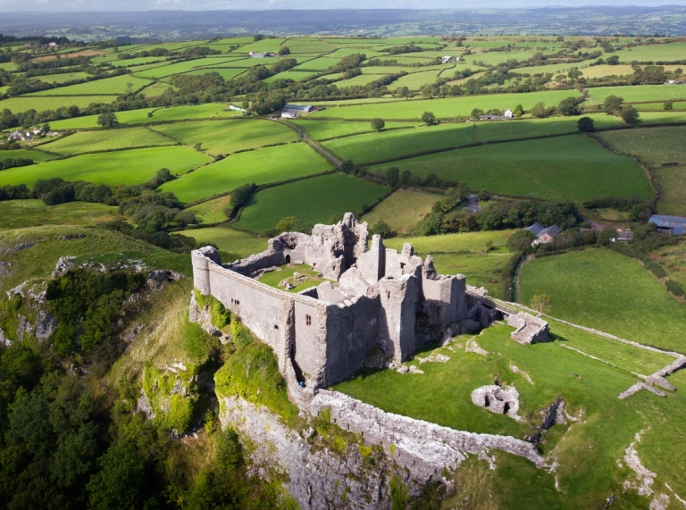 Aerial view of a castle on a hill with commanding views of the countryside.