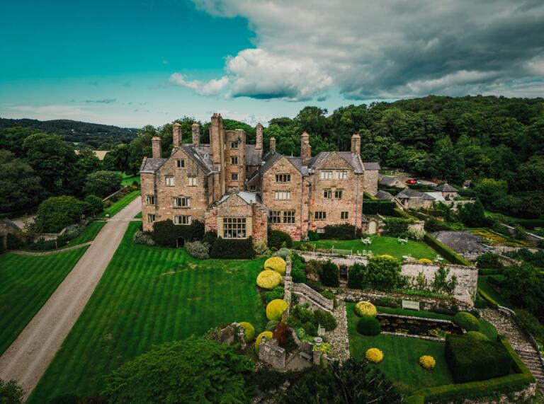 Drone image of Bodysgallen Hall with green land around the stone building 