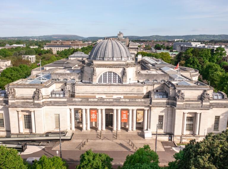 exterior aerial image of teh national museum Cardiff white stone building with green trees surrounding