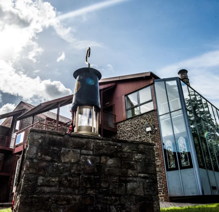 A mining lamp on a wall outside a mining visitor centre.