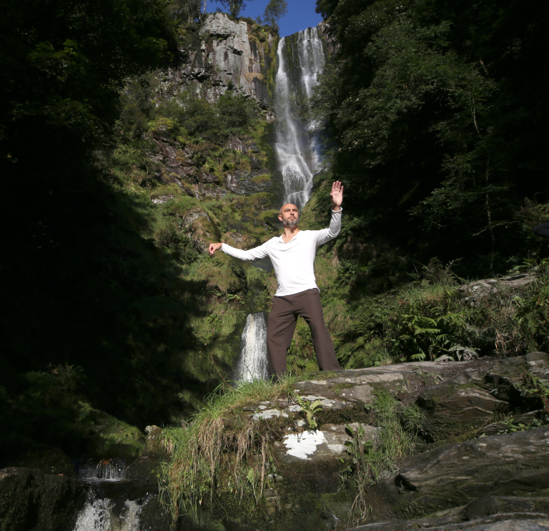 Image of a person in front of a waterfall.