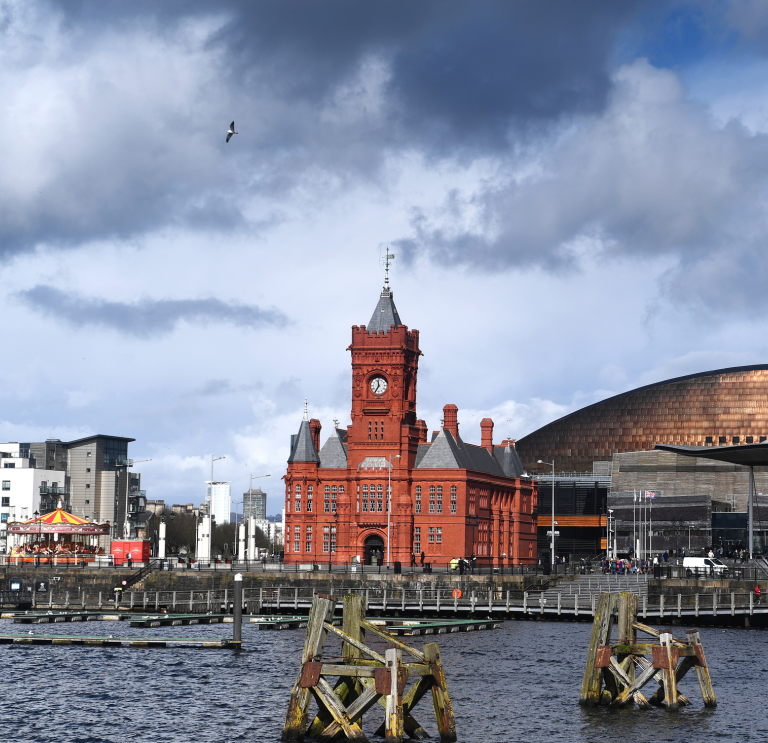 Historic red brick building with clock tower and copper coloured roof building.