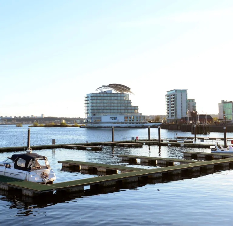 Boats marined on a bay with a hotel in the background.