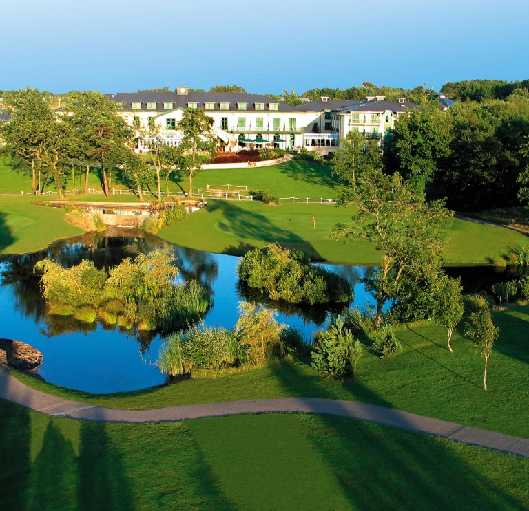 Aerial shot of a hotel, lake and golf course.