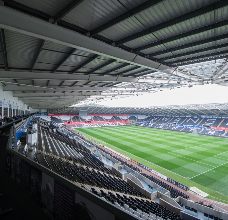 Ground view overlooking the hospitality boxes stand seats and green pitch.