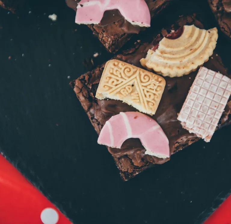 A chocolate brownie decorated with biscuits