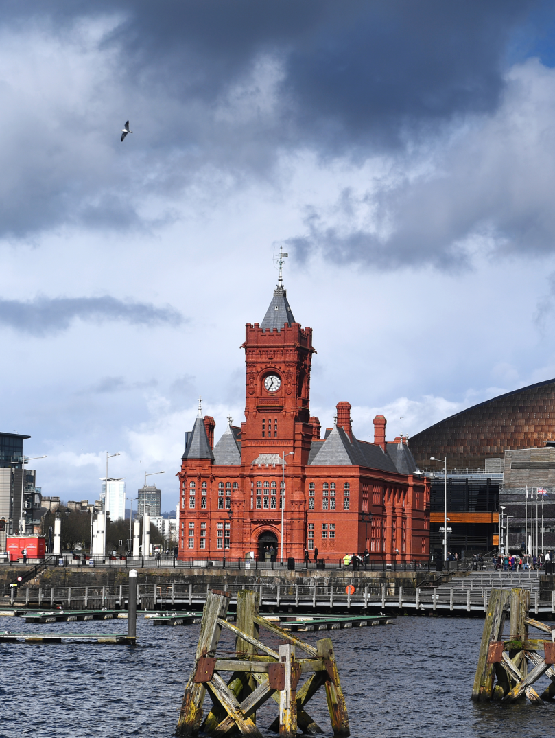Historic red brick building with clock tower and copper coloured roof building.